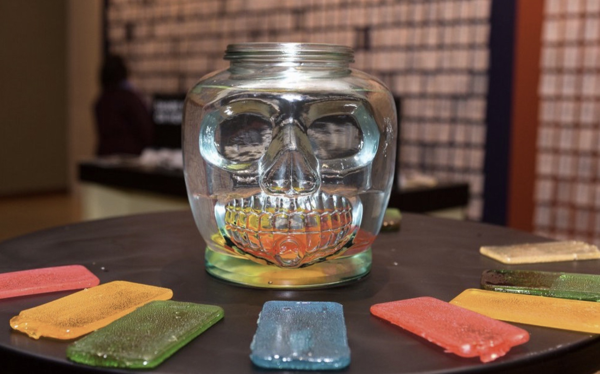 purAPPification, 2018 — glass skull vessel with candy-cast mobile phones dissolving in water, from Smile of Breath at The Rubin Museum of Art, New York, by Hannes Bend