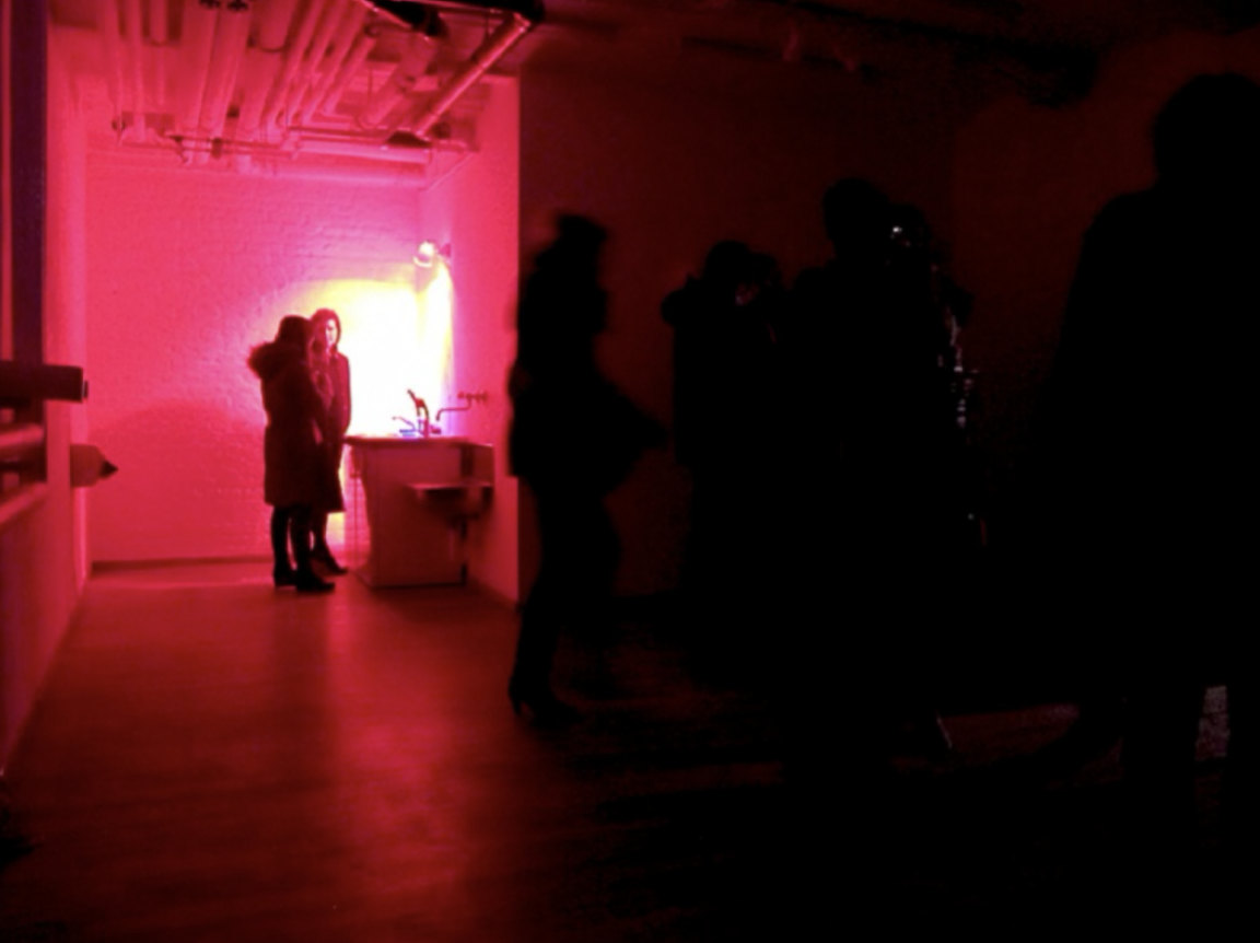 IN & OUT, 2004/2013 — opening night view of the hot room with visitors silhouetted against red lighting