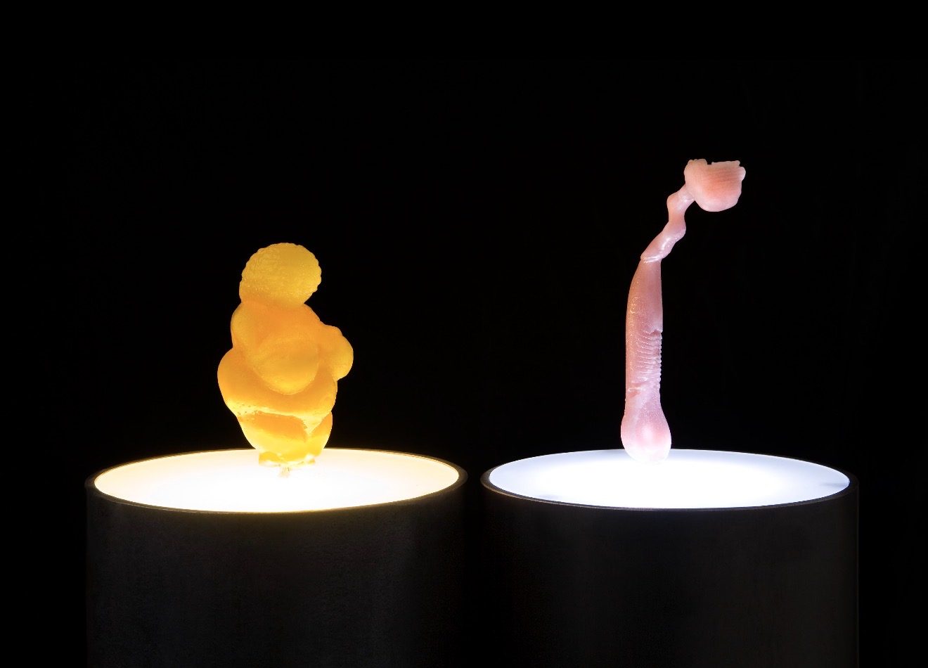 VENUS, 2008 — candy cast sculpture of the Venus of Willendorf (left) and a Venus Breeze Gillette shaver (right) on illuminated pedestals, by Hannes Bend
