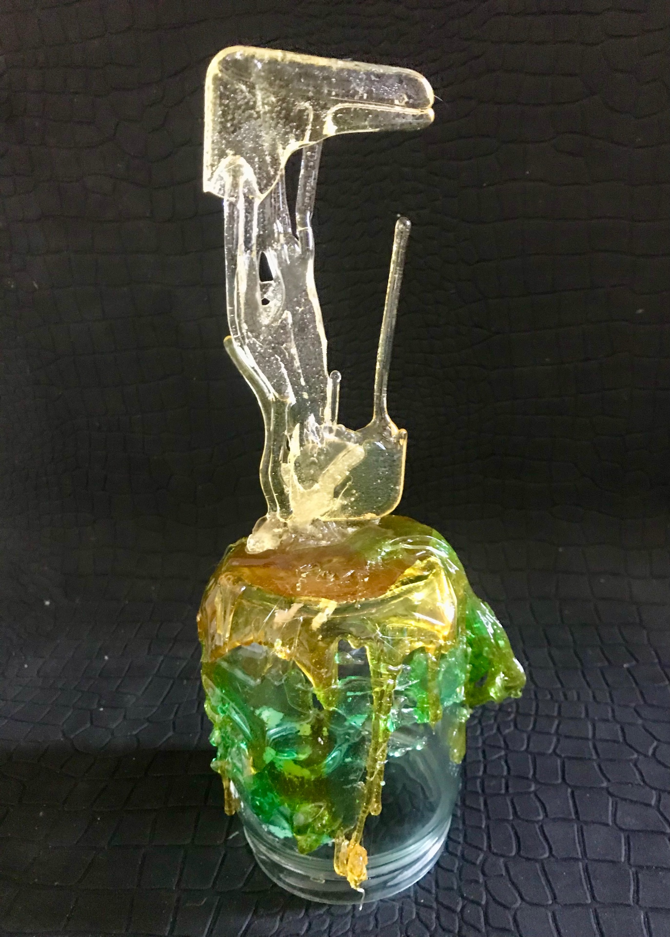 Cracked phone (green), 2018 — candy cast in translucent green with amber drips over a clear glass vessel, by Hannes Bend
