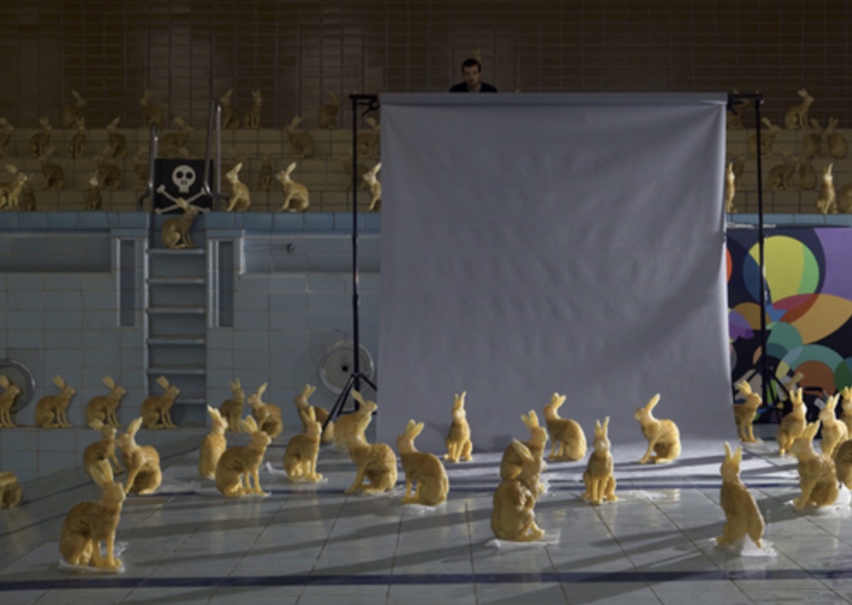 Hasenbad / Bunny Pool, 2009 — installation view of dozens of life-size candy-cast rabbits arranged in an empty tiled swimming pool with a suspended white backdrop, photograph by Hannes Bend and Anne Deppe