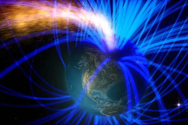 Illustration of Earth wrapped in blue magnetic field lines, with a stream of particles from the Sun arriving from the upper left.