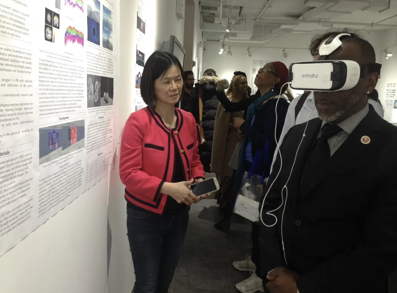 A visitor wearing a VR headset while another person stands nearby at a public art event.